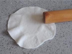 取一个小剂子，稍微沾点粉，用擀面杖擀成圆形，用力将四周压薄，变成四周薄中间厚的圆片，再用擀面杖的一头沿着面片的周围用力擀压，让周围变的更薄，成木耳状