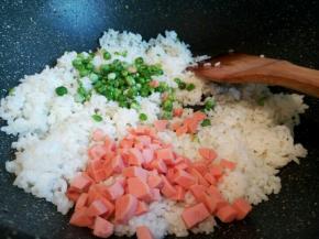 锅里放一点点油，先把米饭炒一下，再倒入火腿肠丁和豌豆丁翻炒，