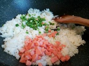 锅里放一点点油，先把米饭炒一下，再倒入火腿肠丁和豌豆丁翻炒，