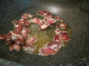 锅里放油，煸炒腊肠片，