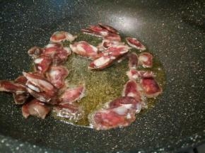 锅里放油，煸炒腊肠片，