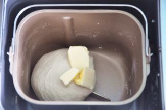 揉至面筋扩展，表面光滑，加入软化的黄油。