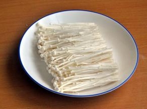 金针菇剪去根部，洗净沥水，整齐摆在盘中央。