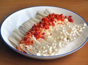 将小米椒和蒜剁碎铺在金针菇上面，辣椒根据个人喜好放。