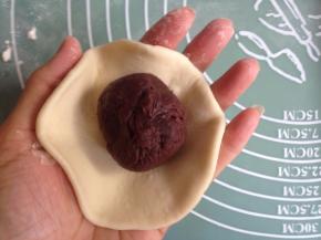 将面团擀圆，中间厚四周簿，中间放入馅料，收口，搓圆