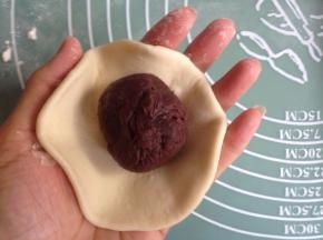 将面团擀圆，中间厚四周簿，中间放入馅料，收口，搓圆