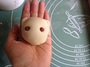 用拇指和食指在两边捏出耳朵，将红豆插入两边做眼睛