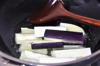 锅中倒入适量油，热至7成后倒入茄子，炸茄子至表面变软。