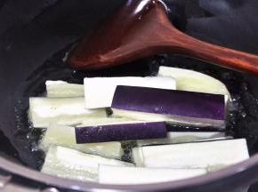 锅中倒入适量油，热至7成后倒入茄子，炸茄子至表面变软。