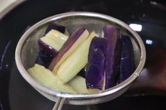 捞出茄子，沥干油备用。