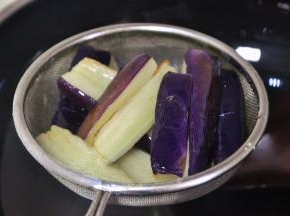 捞出茄子，沥干油备用。