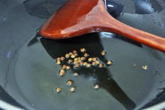 此时锅中留下少量的油，倒入花椒。