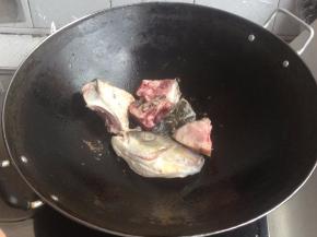 放姜片和鱼头，炒几下