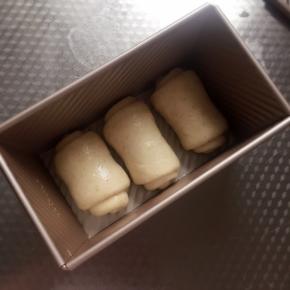 顺着一个方向放入吐司模中，盖上保鲜膜。放在温度37度左右，湿度75％的环境下发酵。