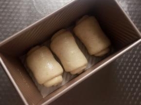 顺着一个方向放入吐司模中，盖上保鲜膜。放在温度37度左右，湿度75％的环境下发酵。