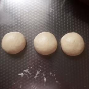 取出，放成三等份，滚圆。盖上保鲜膜松弛8～10分钟。