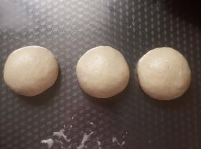 取出，放成三等份，滚圆。盖上保鲜膜松弛8～10分钟。