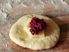 馅料均匀分六份 取一个面团 拍扁包入馅料 捏紧收口 收口向下 滚圆