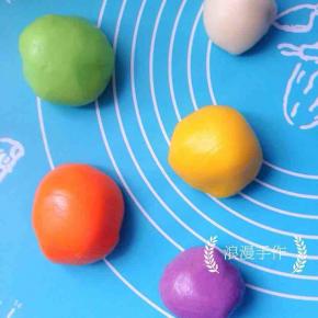 把胡萝卜粉、紫薯粉、抹茶粉和南瓜粉分别与一个冰皮团子揉匀。