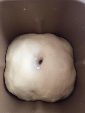 把面包机的搅拌叶拿出来，放入揉好的面团启动发酵功能，面团发酵至2倍大，手指沾面粉在面团中间扎一小洞，面团不反弹不回缩就代表面团发酵好了