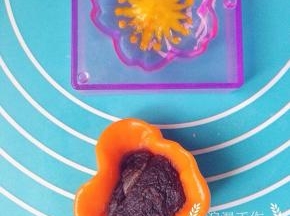 胡萝卜粉团取25克包入一个豆沙馅儿，慢慢收紧口，放入刚刚填满花纹的阳晨和果子模具中。
