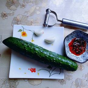 准备食材；简单的食材，黄瓜洗干净，蒜瓣拍成泥。