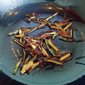 锅中加入适量油，放入切好的小葱，小火把香葱炒至干黄，如图。