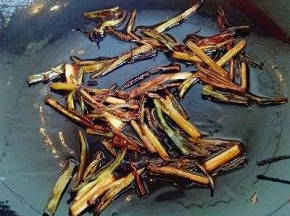 锅中加入适量油，放入切好的小葱，小火把香葱炒至干黄，如图。