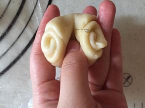 取一个面团对折，按扁，擀皮