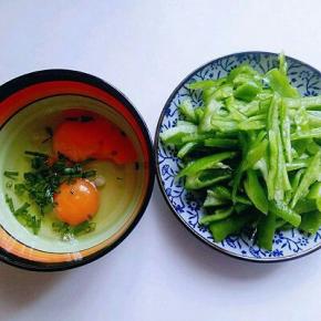 鸡蛋敲碗里，加入葱花，用筷子打散，尖椒去跟，去籽切丝。