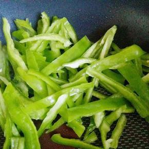 锅中加入油，加入青椒丝，盐，十三香，生抽煸炒。