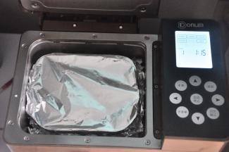 在面包桶上盖一张锡纸，防止果酱飞溅，便于后期清洗，启动果酱程序，我的面包机时间为1小时15分钟，不同的型号时间略有差异。