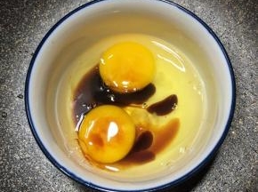 鸡蛋打入碗里，滴入几滴酱油，用筷子搅拌均匀。