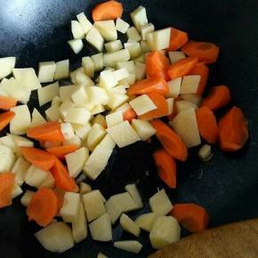 锅中加入适量油，油温7成时加入切好的土豆煸炒，再加入胡萝卜。