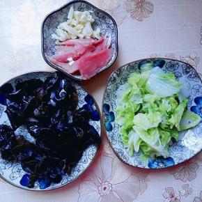 木耳泡发，撕成小块，洗干净，白菜挤干水份。肉切片，蒜去皮切碎。