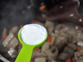 倒入一勺糖，翻炒均匀。