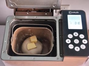 揉至面筋扩展，表面光滑，加入软化的黄油。