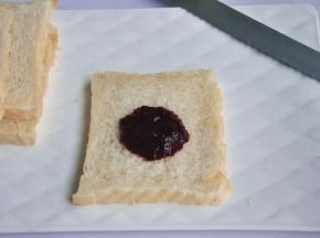 出炉后立即脱模，在晾架上散热，取出后最好先侧放一会儿，以免凹腰，待完全凉透再切片，取一片吐司，抹上草莓桑葚酱。