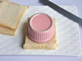 取一个比吐司更小的碗，重重的扣在吐司上面，确保压紧后，再用小刀割去边角料。