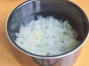 将银耳黄色的根部去掉，撕成小朵，加入适量水。