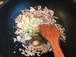 炒至肉变色，放葱和蒜，继续煸炒至肉缩小很多。