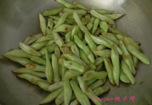 炒锅内倒入食用油，放入切好的扁豆段编至上色，取出备用；