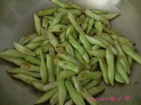 炒锅内倒入食用油，放入切好的扁豆段编至上色，取出备用；