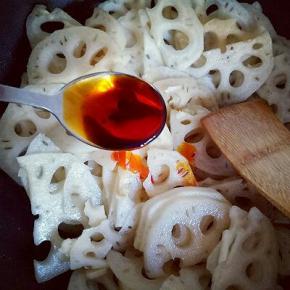 锅中加入食用油，油温7成时加入蒜炒香，再加入切好的莲藕煸炒，再加入调味料。醋。老干妈辣酱，生抽，耗油，几滴芝麻油，糖。