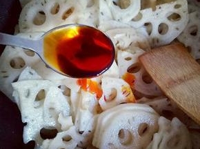 锅中加入食用油，油温7成时加入蒜炒香，再加入切好的莲藕煸炒，再加入调味料。醋。老干妈辣酱，生抽，耗油，几滴芝麻油，糖。