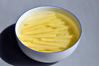 先把土豆洗好，去皮切条，之后放盐水中浸泡十分钟，土豆尽量选个头大，比较规则的。