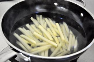 将土豆放入开水中煮三分钟。