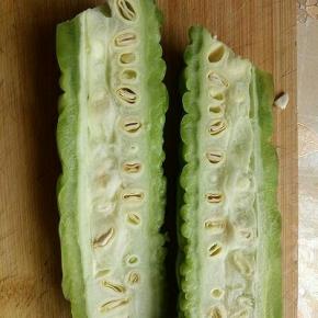 首先苦瓜一切二，也就是从苦瓜的中间切开。