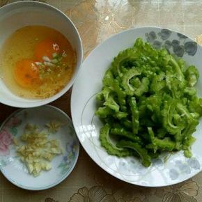 苦瓜切片，鸡蛋敲碗里，加入十三香，葱花用筷子打散，蒜切碎。