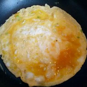 不找锅中加入适量油，倒入打散的蛋液，小火煎鸡蛋饼，再切小块，盛出备用。